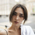 Young woman smiling in natural light, representing Timeless Beauty products and radiant style.